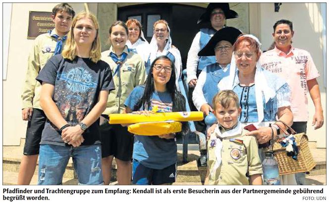 Pfadfinder und Trachtengruppe zum Empfang: Kendall ist als erste Besucherin aus der Partnergemeinde gebührend begrüßt worden.   |   Quelle:&nbsp;DIE RHEINPFALZ - Ludwigshafener Rundschau -&nbsp;7. Juli 2022 - Text & Foto:&nbsp;Ulrike Dansauer - 2. Foto:&nbsp;DPAK - Mit freundlicher Genehmigung der&nbsp;RHEINPFALZ Verlag und Druckerei GmbH & Co. KG in Ludwigshafen.&nbsp;
